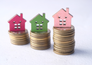 Houses on top of money showing interest rates dropping